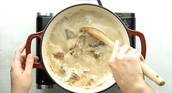 Letting the spices and beef chunks simmer in a pot.