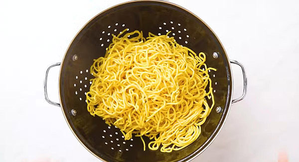 Yellow noodles in a colander. 