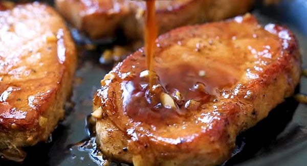 This image shows the Pork Chops being basted with the sauce.