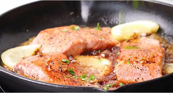 Honey garlic salmon with lemon slices garnished with parsley. 