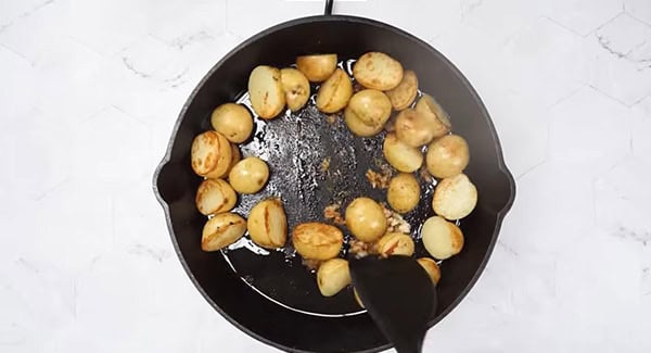 This image shows the potatoes being mixed with the spices.