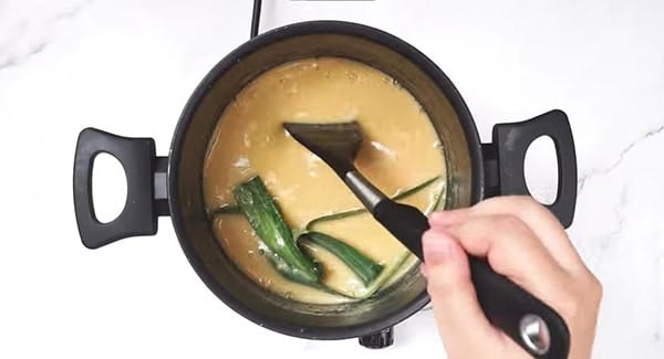 This image shows the Pandan Leaves and Cornstarch being added into the mixture.