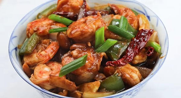 Kung Pao Shrimp being served in a bowl.