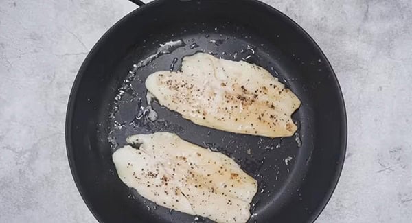 Pan frying seasoned swai fish fillets.