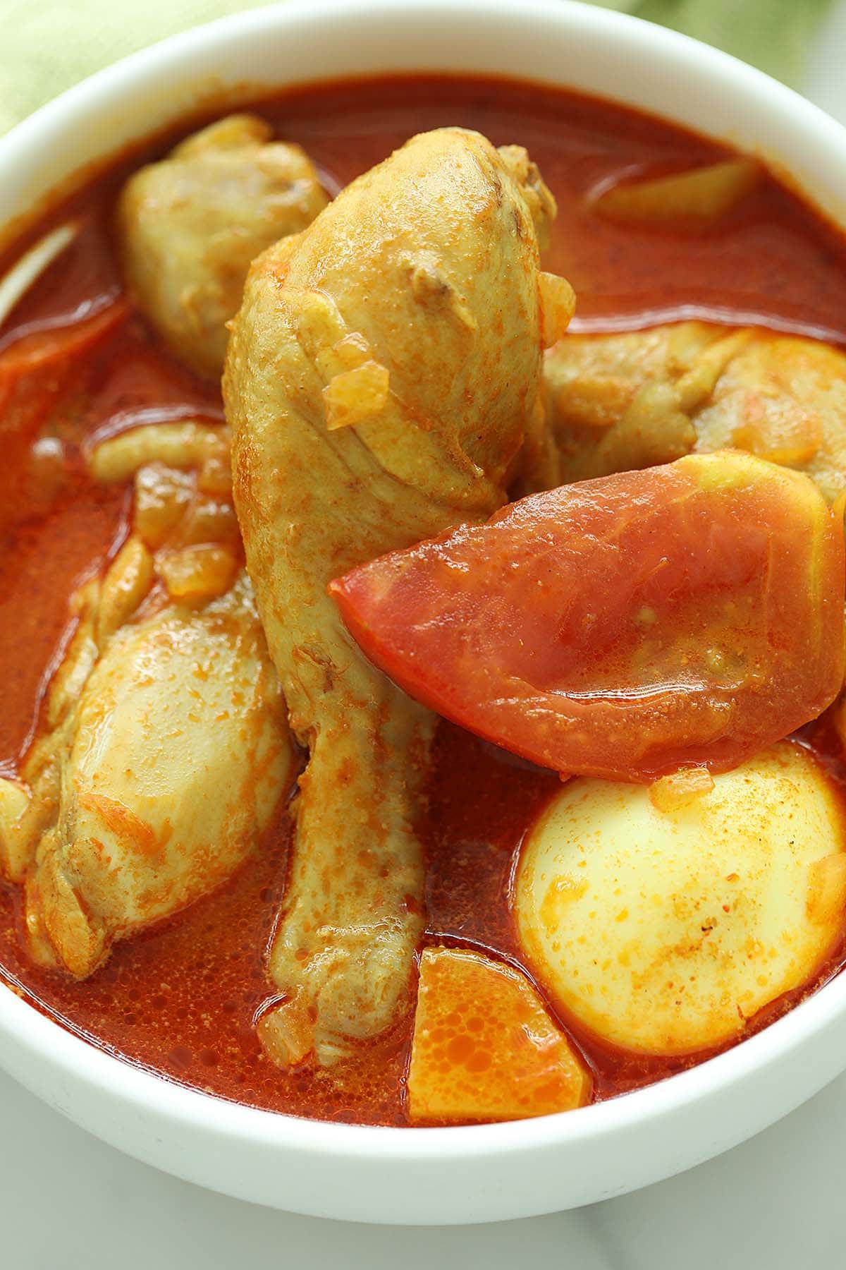 Coconut curry chicken with hard boiled eggs and tomatoes in curry sauce. 