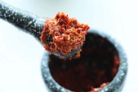 Making sambal for nasi lemak with a mortar and pestle. 