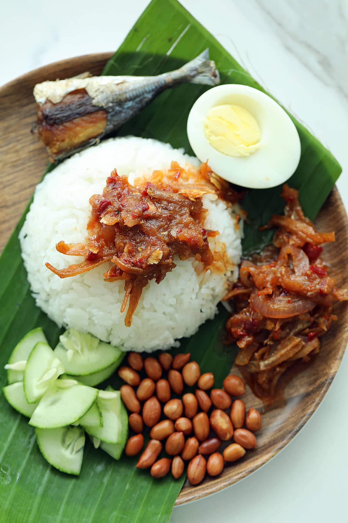 Malaysian nasi lemak served with banana leaf on plate.