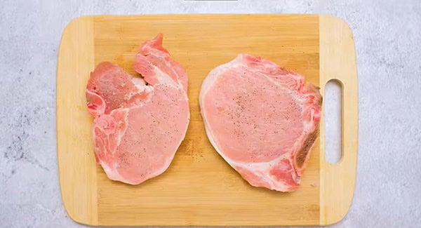 Seasoned pork chips in a chopping board.