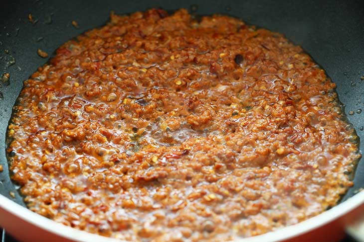 Spice paste added into a hot wok to saute.