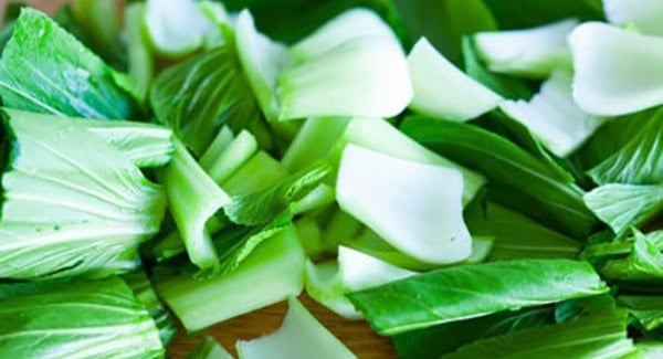 Bok choy cut into pieces on a chopping board. 