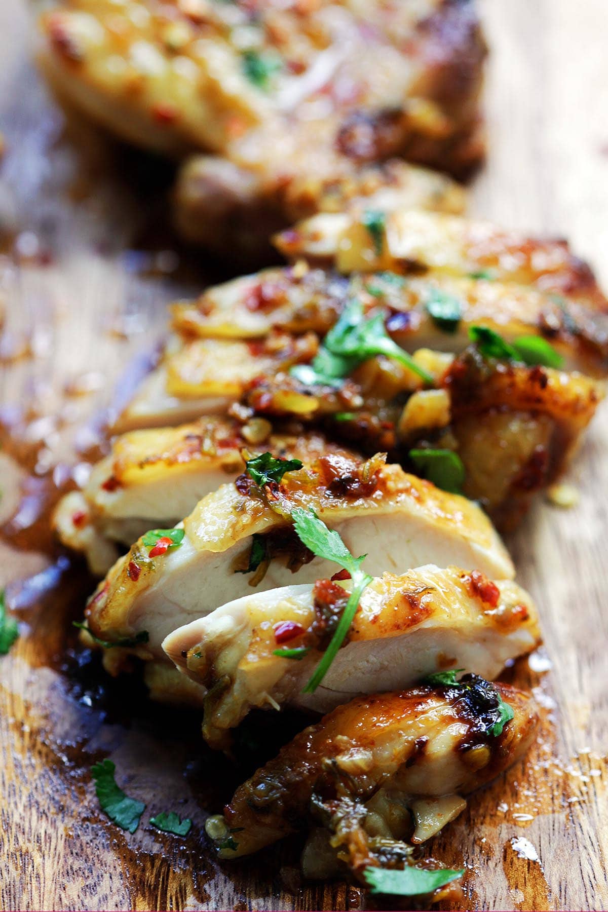 One piece of chicken thighs with cilantro and lime wedges. 