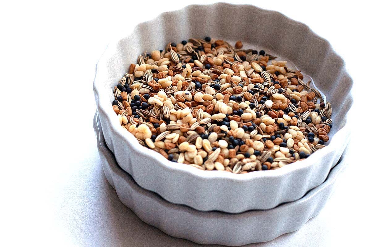 Curry spices in a bowl: fenugreek, black mustard, cumin, and fennel seeds. 