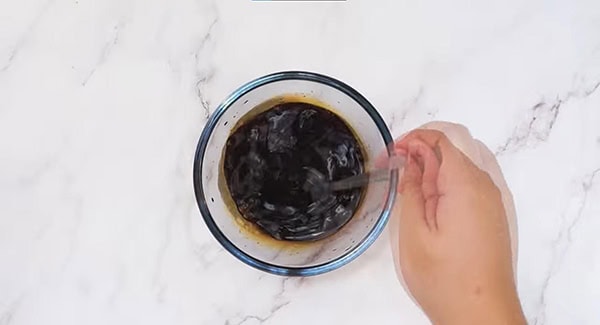 Seasoning sauce in a small bowl being mixed with a spoon. 