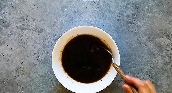 Honey garlic sauce ingredients in a bowl being mixed with a spoon. 