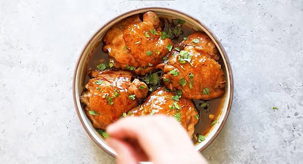 Instant pot honey garlic chicken garnished with parsley and served on a plate. 