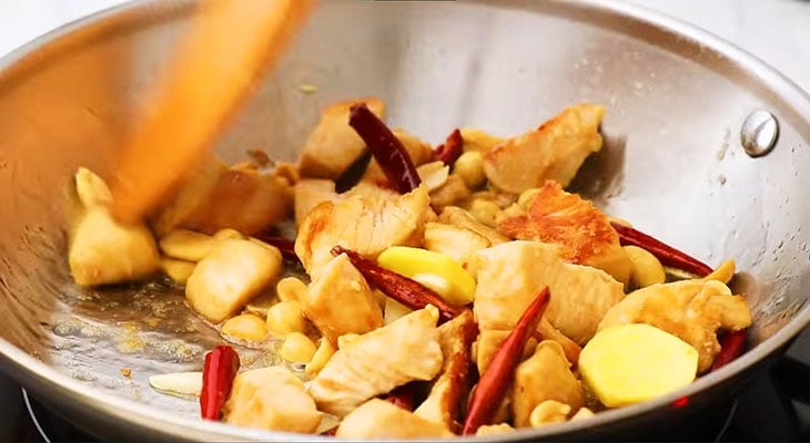 Stir-frying chicken cubes in a pan. 