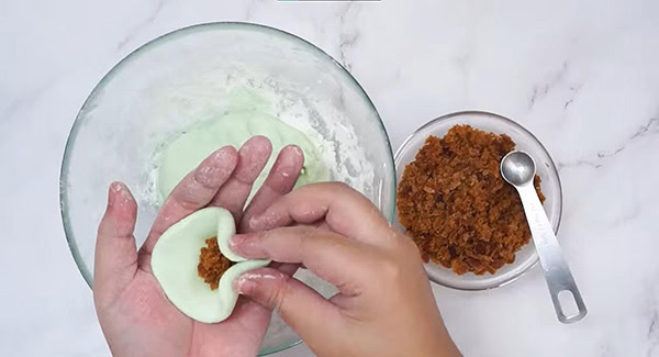 Flattened onde-onde dough with Gula Melaka filling in the center. 