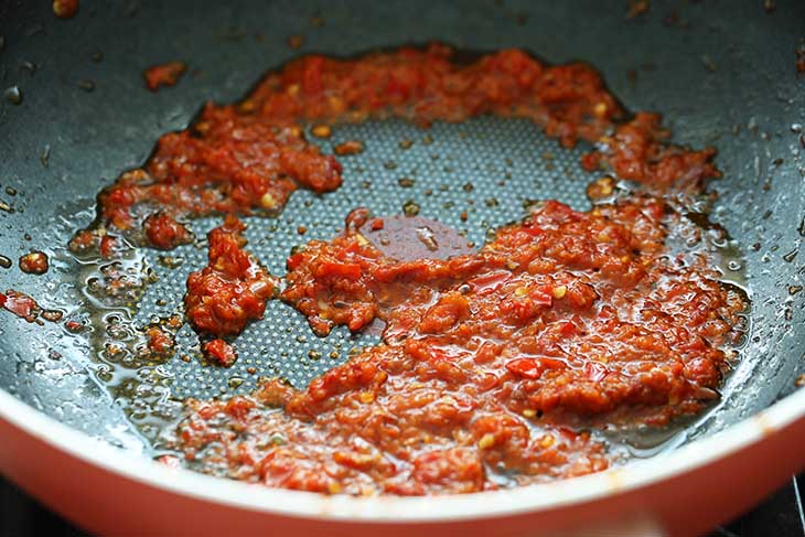 Heating up sambal in a wok.