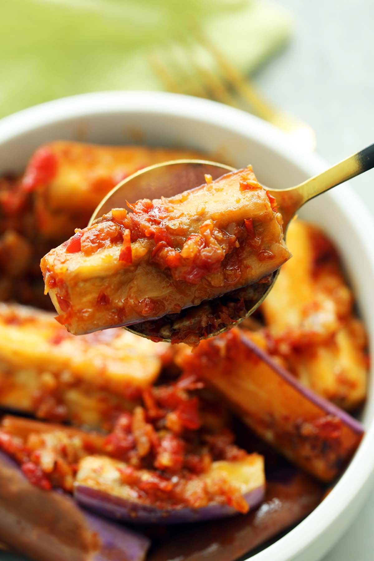 Spicy sambal cooked with Eggplant served on a spoon.