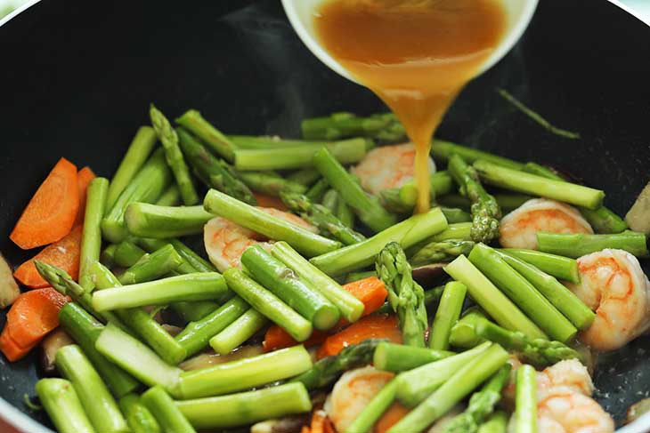 Sauce being added into the pan with the other vegetables.