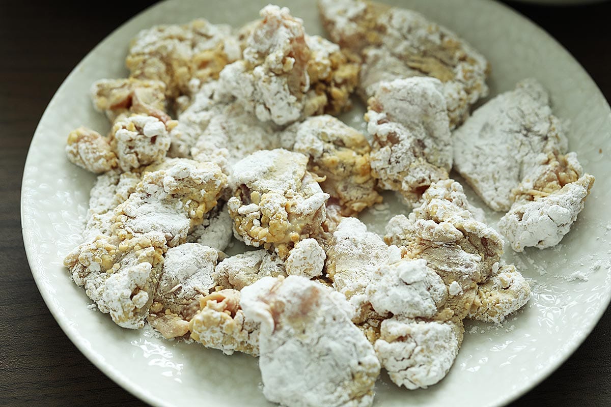 Raw chicken cubes coated with potato starch. 