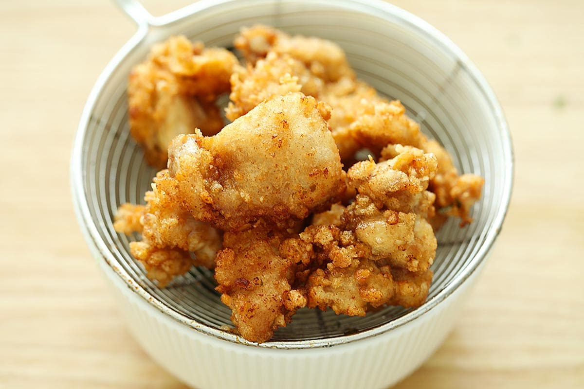 Deep fried Japanese fried chicken on a strainer. 