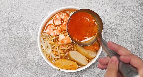 Add the soup on top of the assembled noodles and ingredients. 