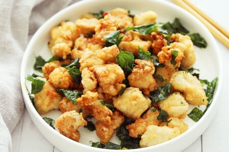 A plate full of crispy and golden brown popcorn chicken nuggets