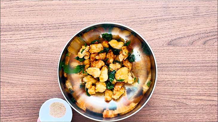 Golden brown fried chicken in a mixing bowl.