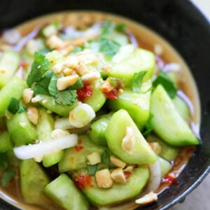 Thai cucumber salad topped with peanuts and in a dressing.