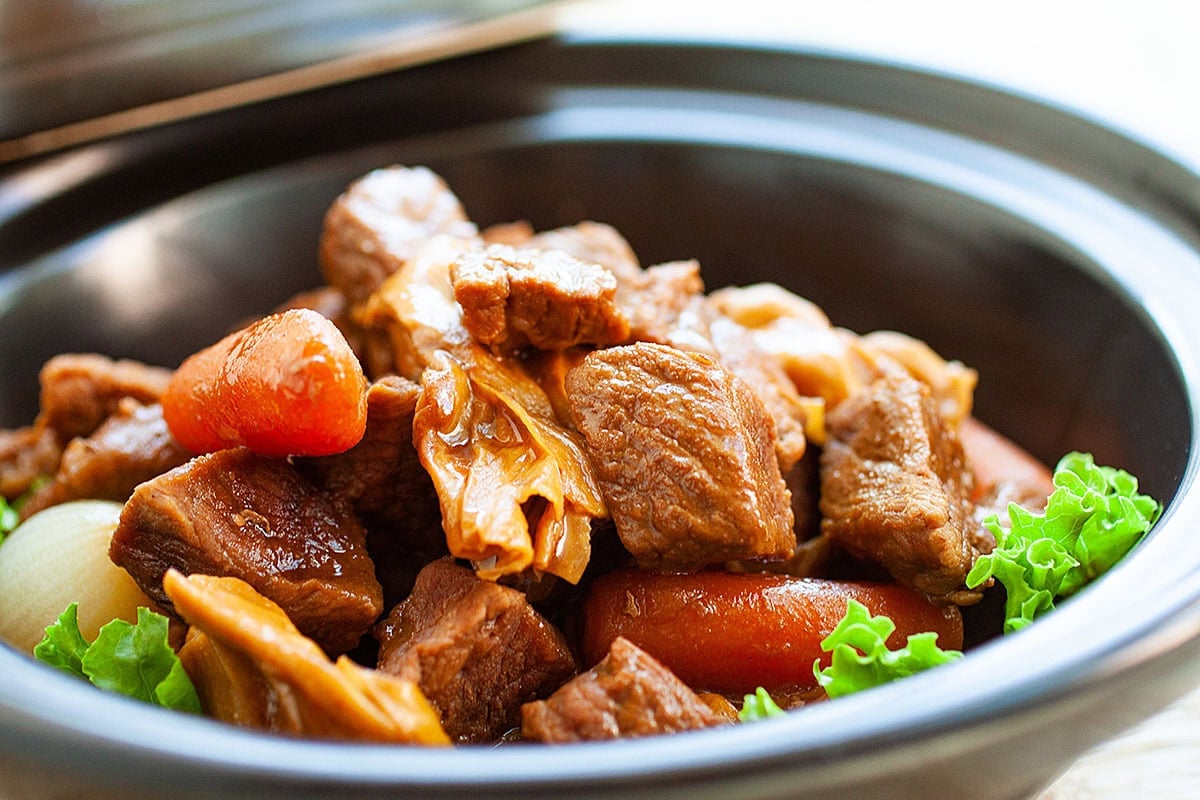 Tender beef, carrots and sauce cooking in a claypot for Cantonese stewed beef. 