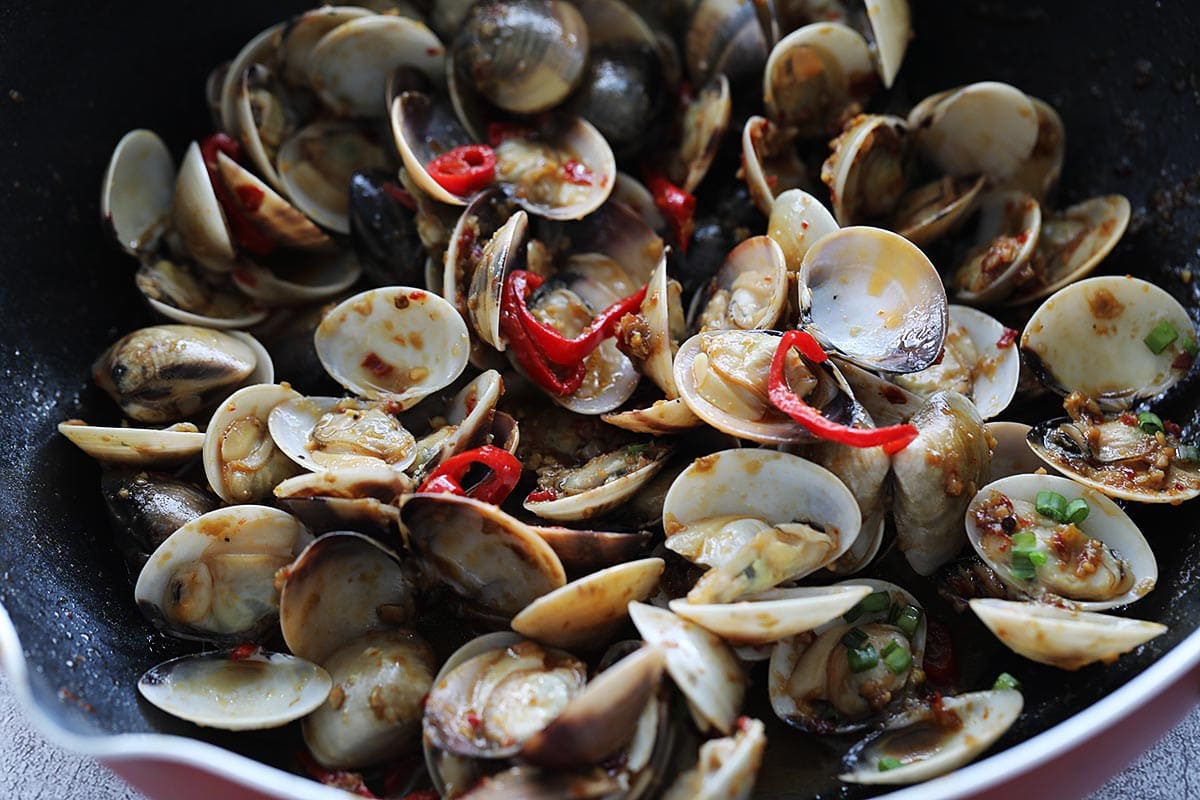 Adding chilies to chili clams stir fry. 