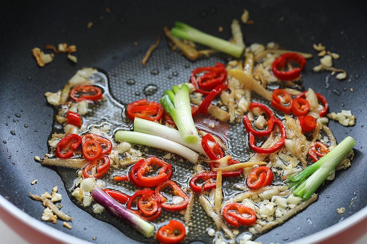 Stir frying the aromatics with oil in a skillet. 