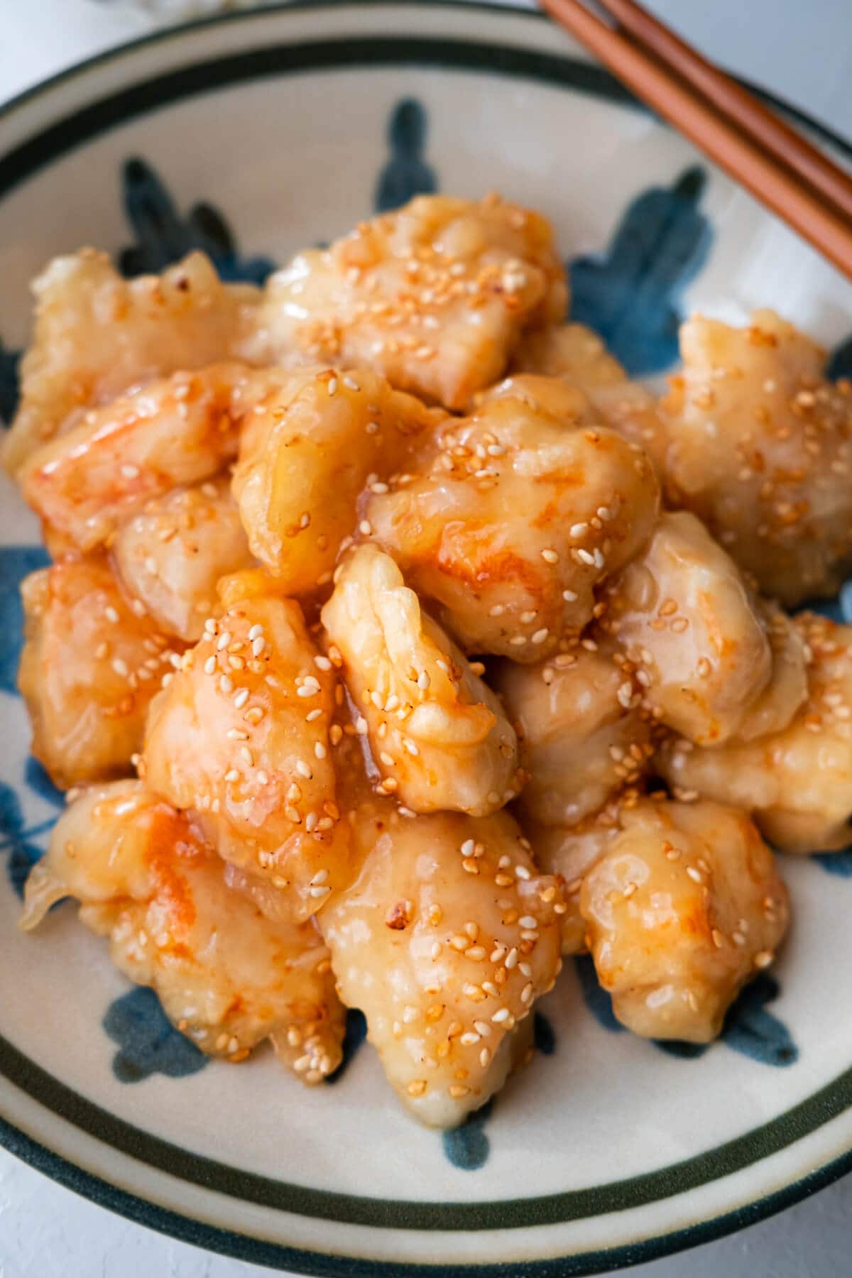 Honey chicken topped with sesame seeds, served in a bowl.