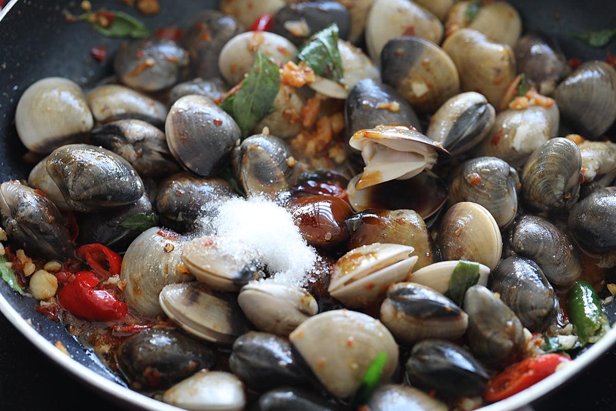 Add the clams and the other ingredients into the wok with the aromatics. 