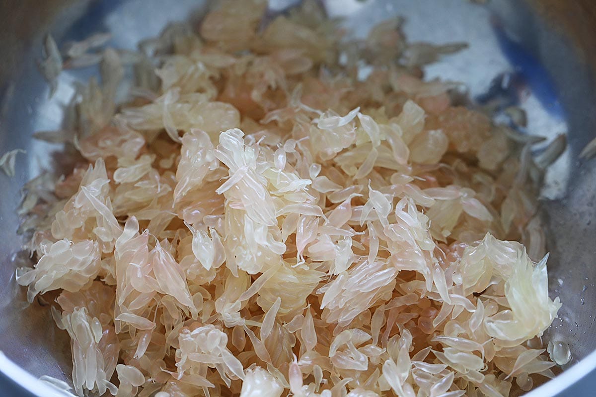 Small pomelo fruit segments in a bowl, ready for pomelo salad dressing. 
