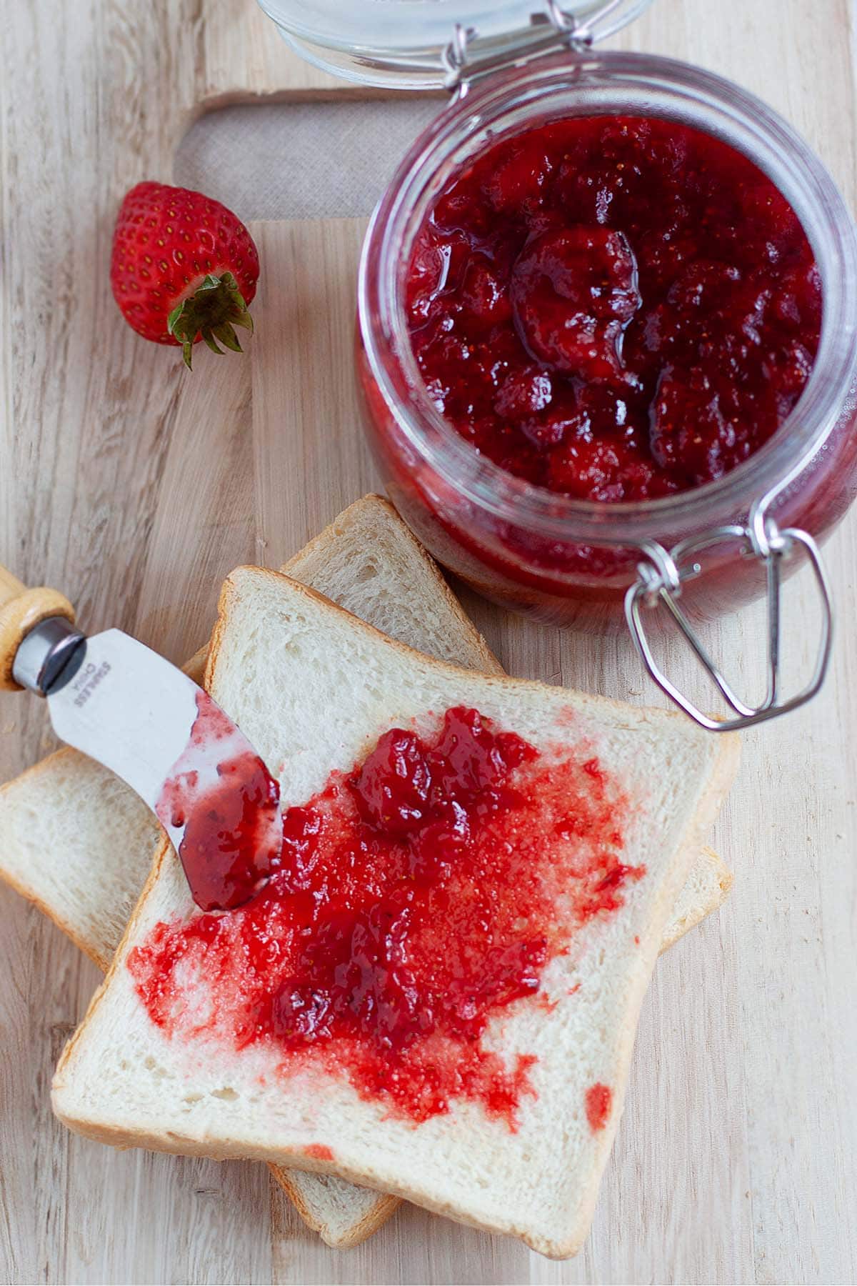 The best traditional strawberry jam recipe, spread on a piece of toast. 