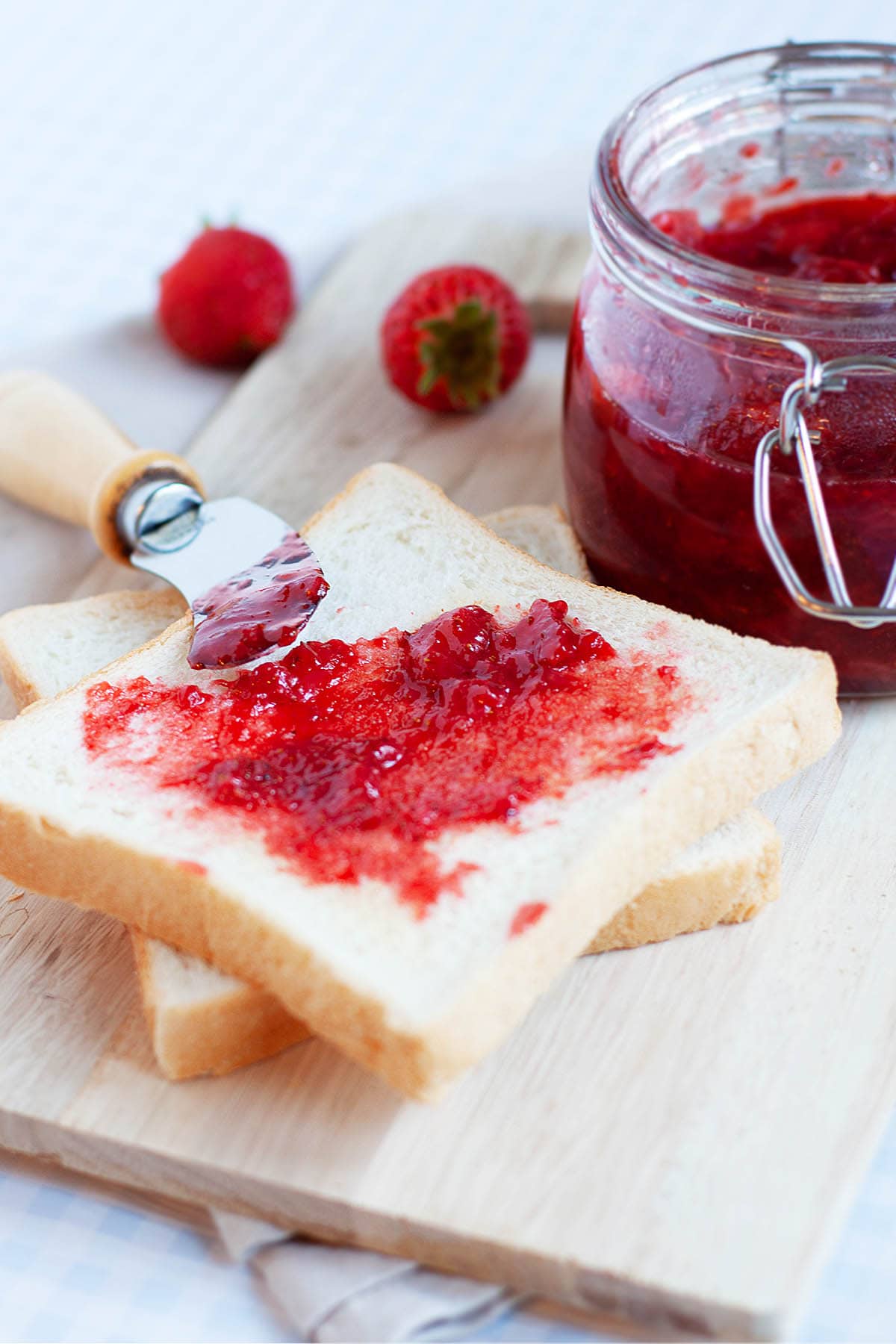 Strawberry jam in a jar with bread. 