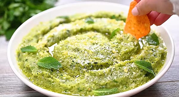 Serve the zucchini dip and top it with grated parmesan, lemon zest and mint leaves. 