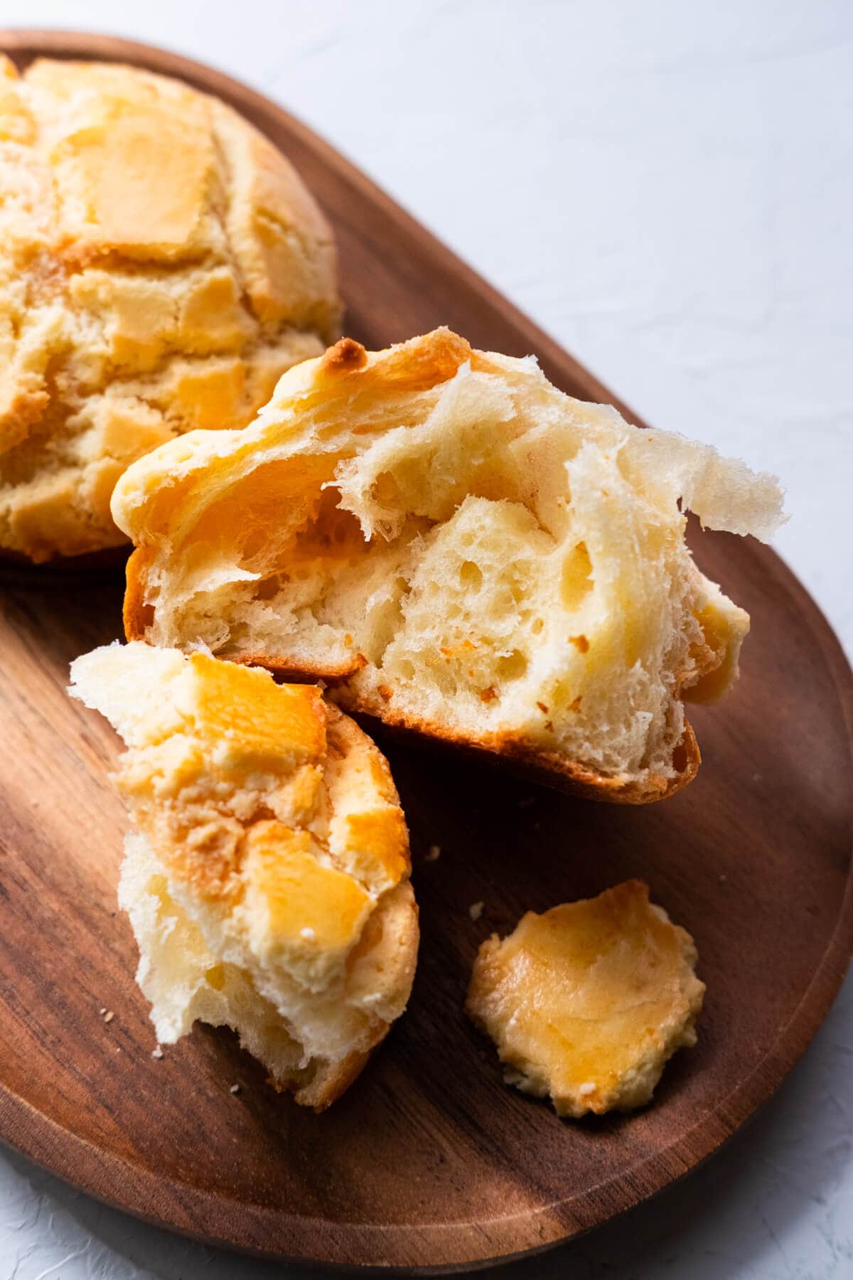 Freshly baked Chinese pineapple bun  recipe torn in half, showing its fluffy, soft inside.