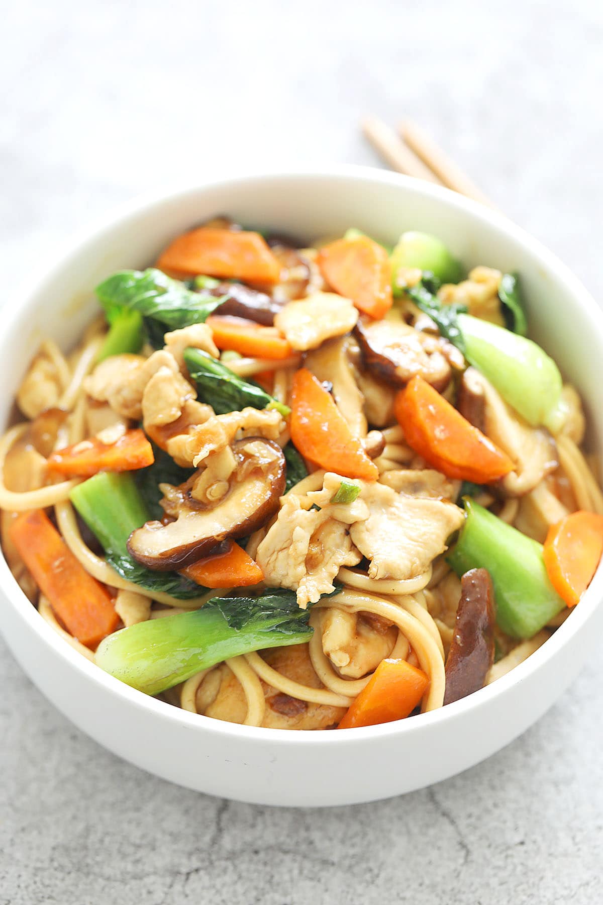 Authentic chicken lo mein stir fry with a pair of chopsticks.