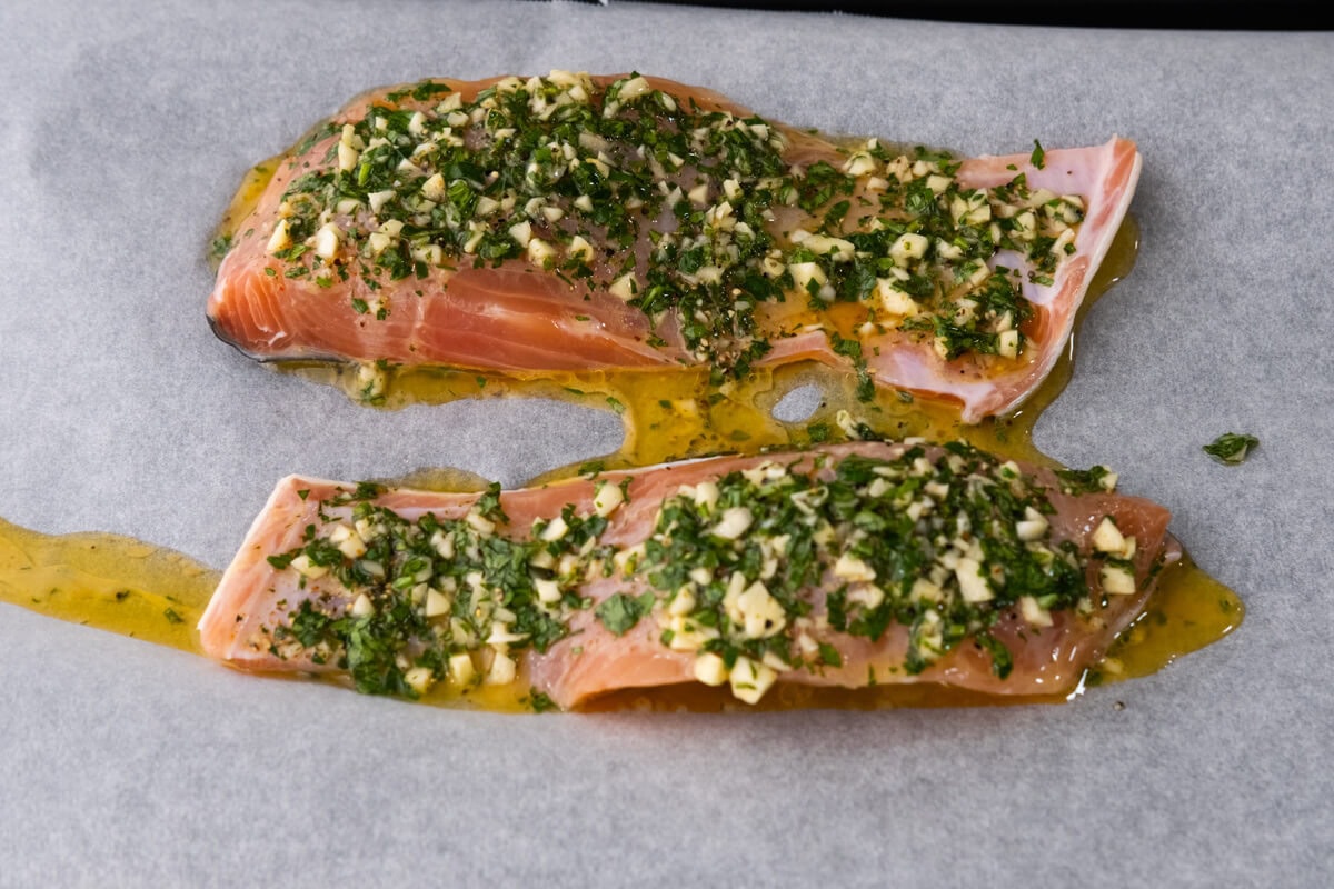 Place the salmon fillets on the baking sheet and spoon the garlic herb mixture on top. 