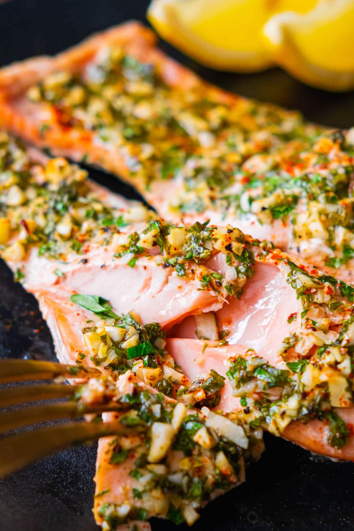 Flaky garlic and herb salmon recipe being torn apart with a fork. 