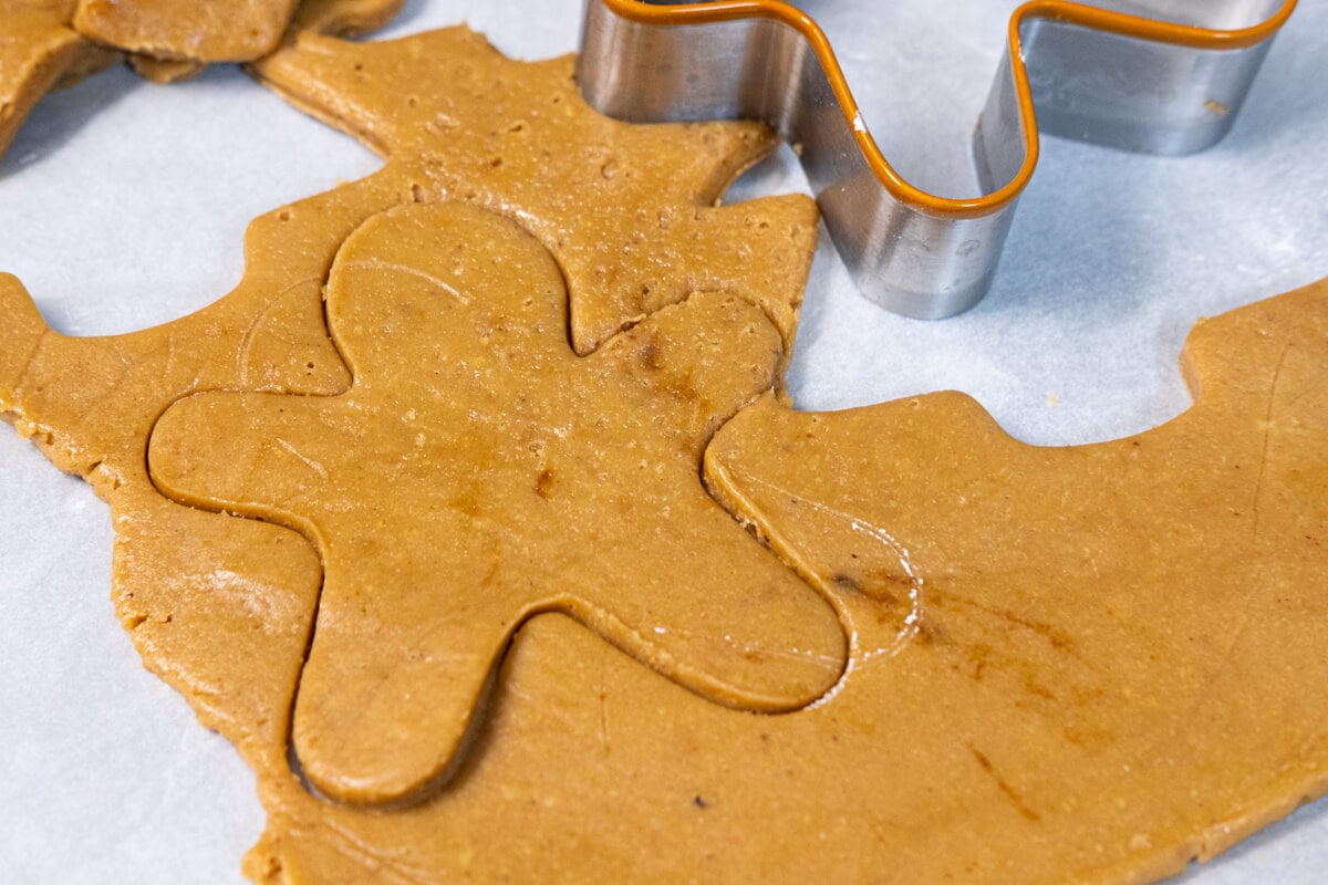 With a lightly floured cookie cutter, cut out shapes for gingerbread men cookies. 