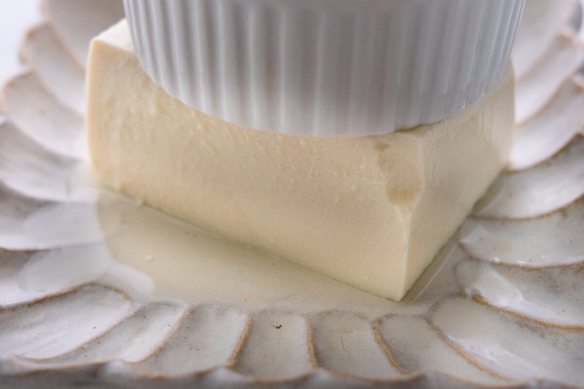 Press the tofu under a heavy plate to remove excess water. 