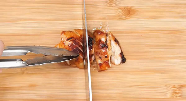 Slice the garlic sriracha chicken into pieces.