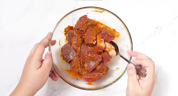 Beef cubes coated in oil and massaman curry paste.