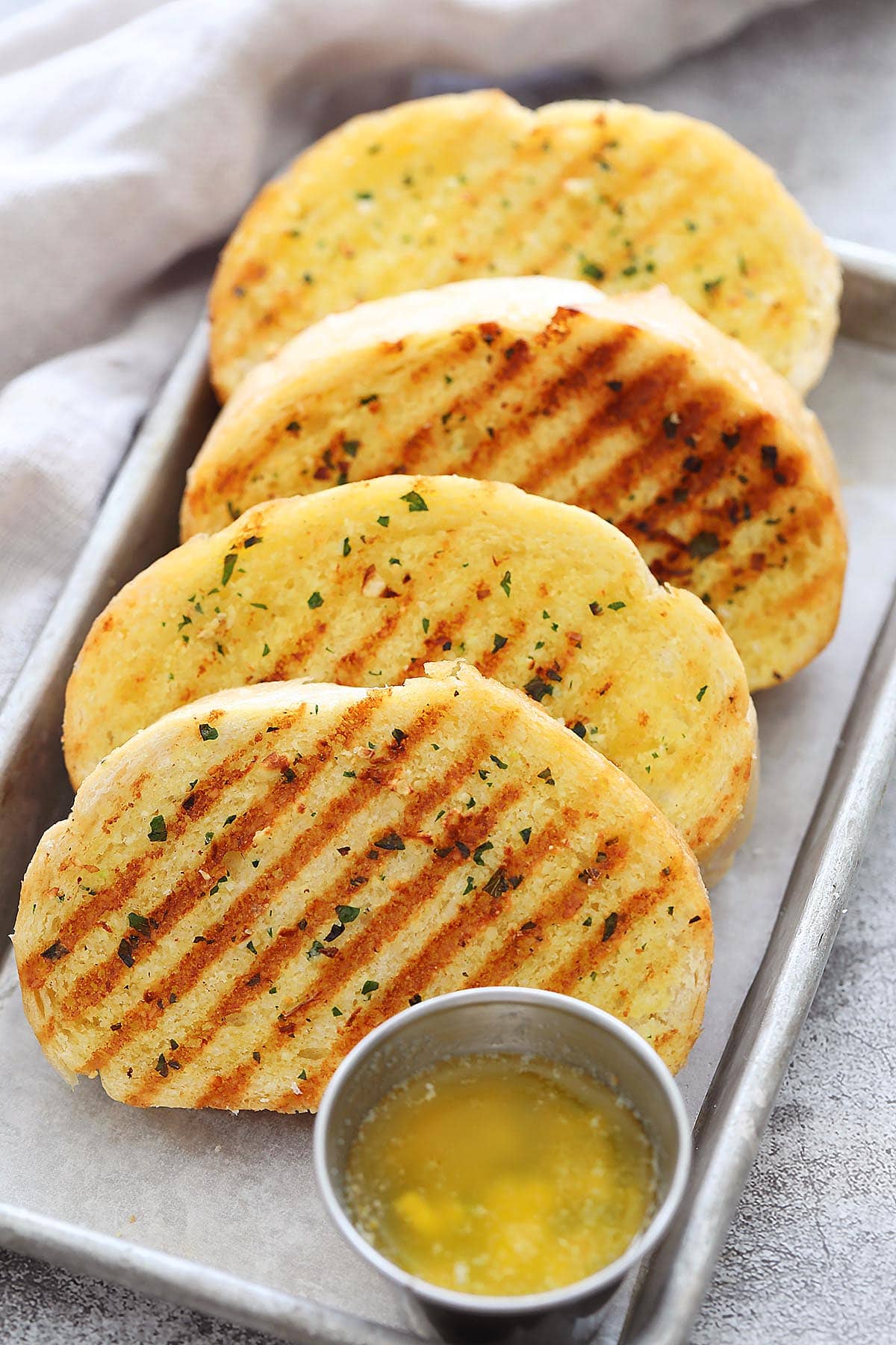 Cast iron skillet garlic bread served with garlic butter.